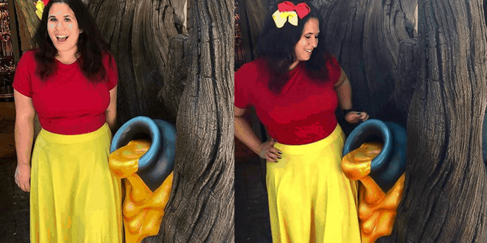 Girl in red shirt and yellow skirt posing next to tree with honey pot