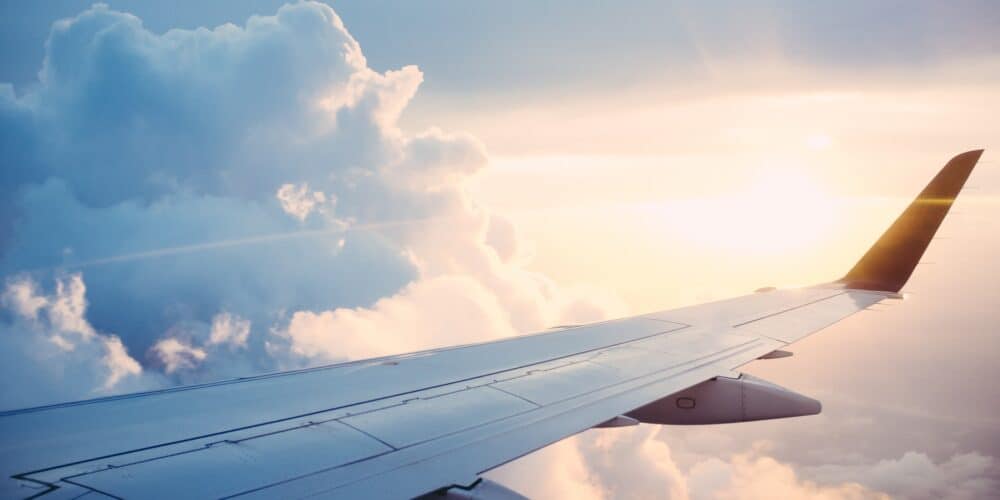 Airplane wing in the air surrounded by clouds