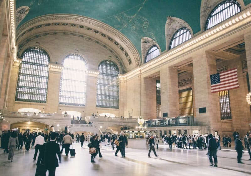 Large domed room with teal painted ceiling and busy people walking through the room