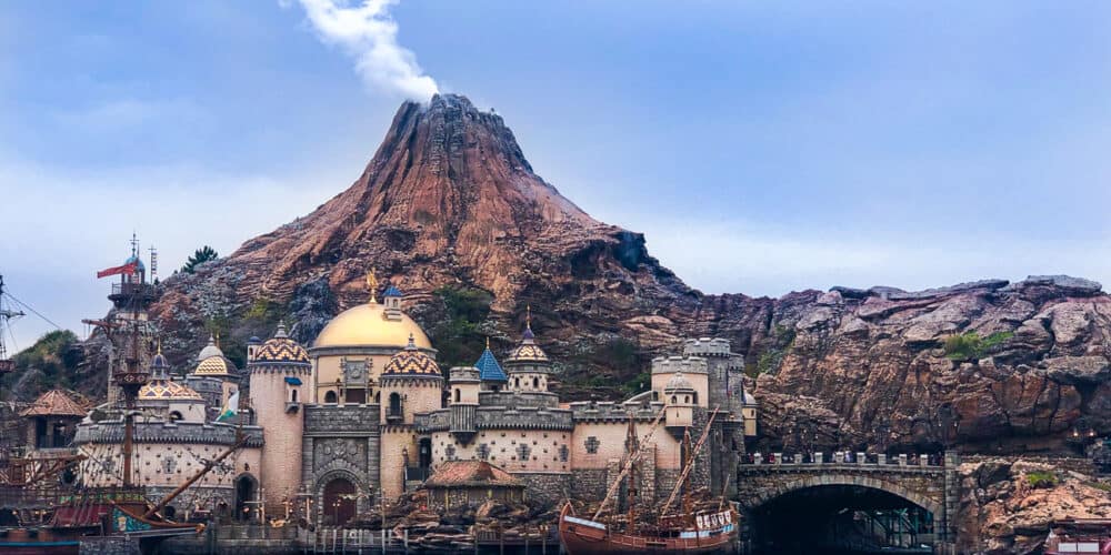 A smoking volcano with a city view and a lake in Tokyo DisneySea