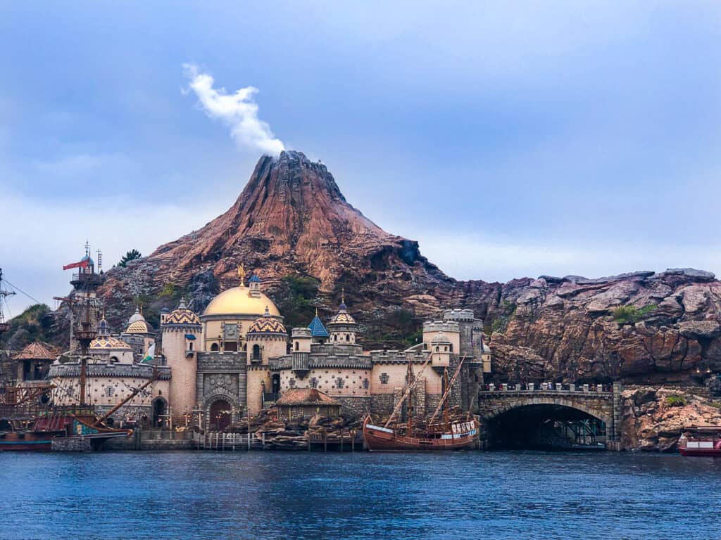 A smoking volcano with a city view and a lake in Tokyo DisneySea