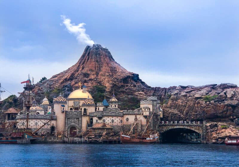 A smoking volcano with a city view and a lake in Tokyo DisneySea