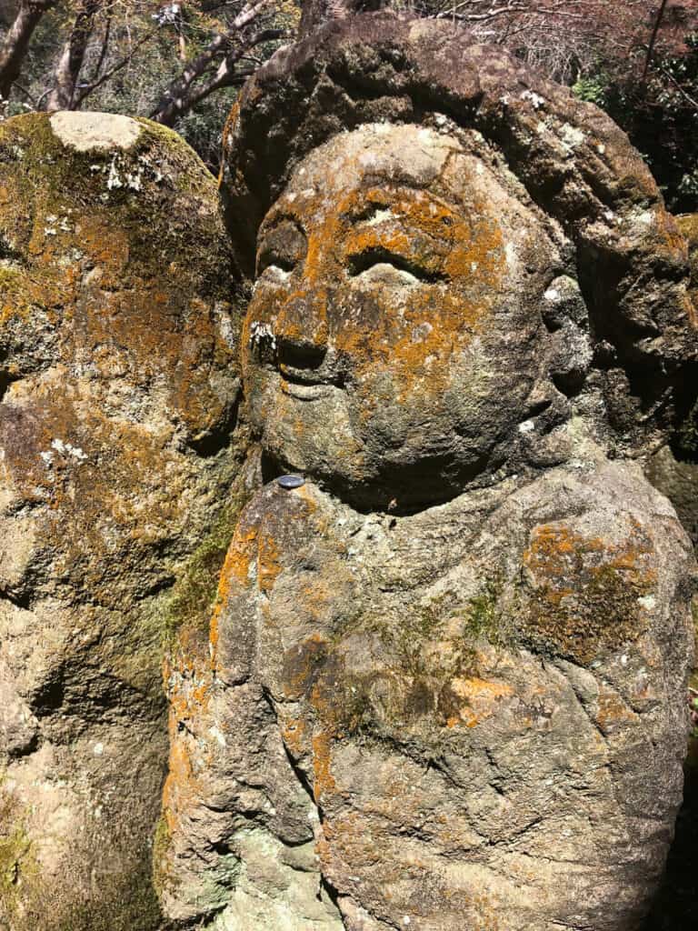 Smiling stone statue in a praying position