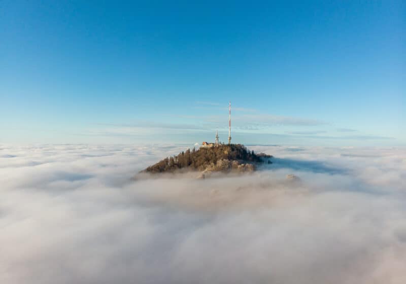 Top of mountain protruding from the clouds