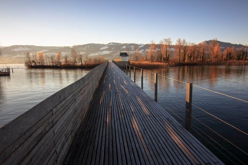 Long wooden pedestrian bridge with mountains in the background