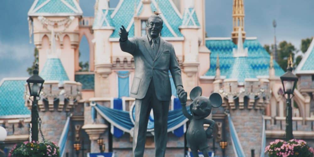 Statue of Walt Disney and Mickey Mouse in front of Disneyland castle