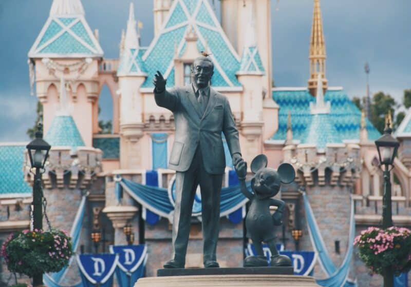 Statue of Walt Disney and Mickey Mouse in front of Disneyland castle