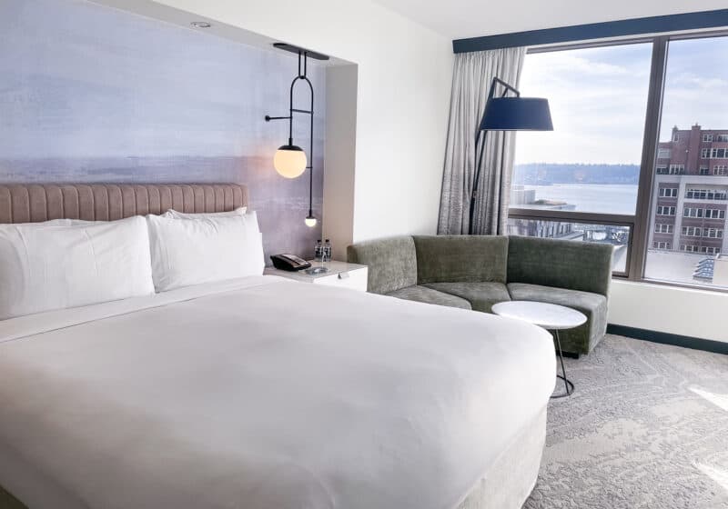Relaxing hotel room with a watercolor headboard and a view of waterfront