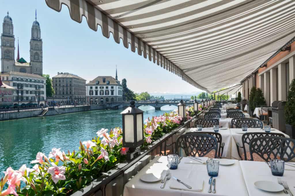 Storchen Zurich hotel terrace with dining tables overlooking a river in a Zurich
