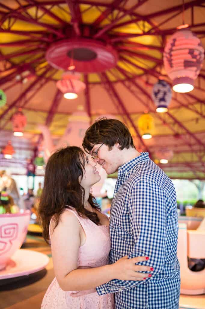 Boy and girl embracing on the floor of disney teacups ride