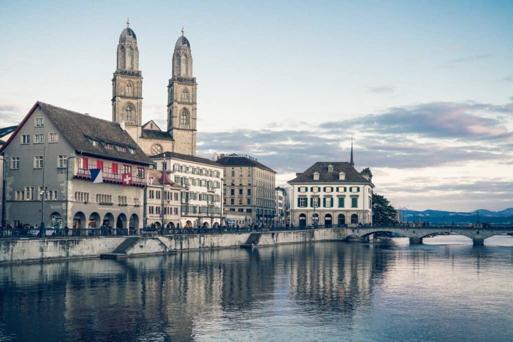 View of downtown Zurich across the water with a large Grossmünster church with two towers in the background