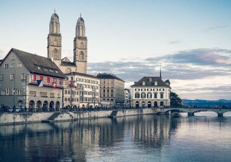 View of downtown Zurich across the water with a large Grossmünster church with two towers in the background