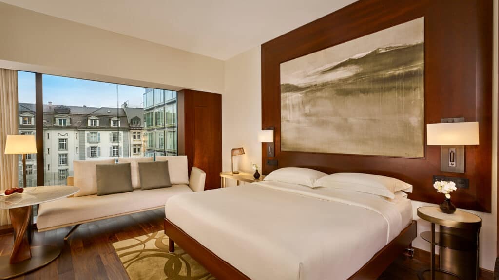 Park Hyatt Zurich high-floor hotel room with a large bed, wooden accents, and a window with a city view