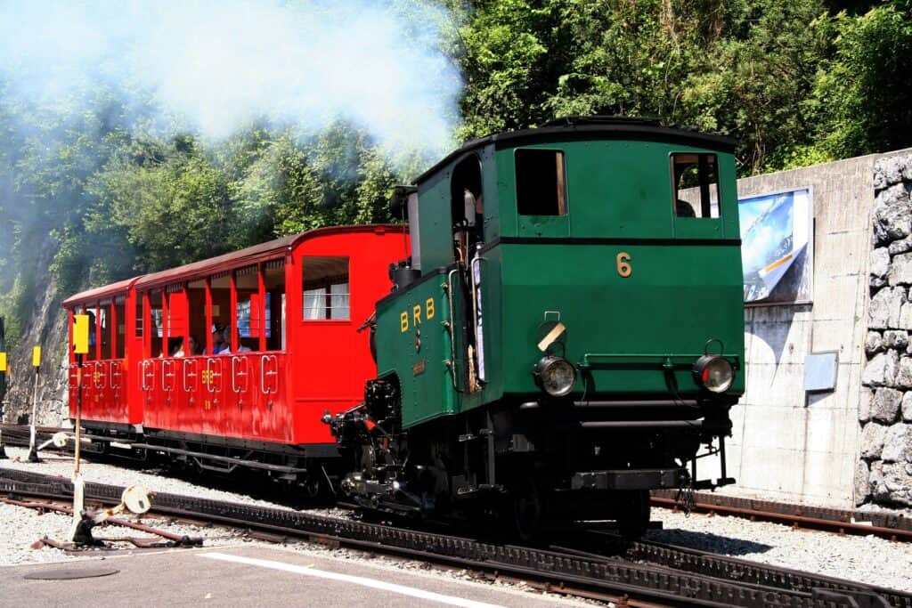 Green Brienz Rothorn Bahn engine with a red passenger car